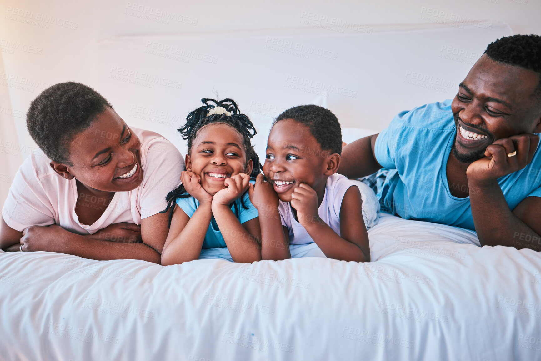 Buy stock photo Smile, bond and black family in bed happy, talking and relax in their home on weekend. Love, face and children with parents in bedroom playful, free and chilling while enjoying conversation together