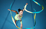 Rhythmic gymnastics, woman in gym and ribbon with balance, action with performance and fitness. Competition, athlete and female gymnast, creativity and art with dancing routine and energy at arena