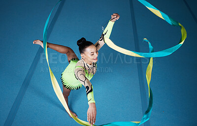 Buy stock photo Rhythmic gymnastics, woman in gym and ribbon with balance, action with performance and fitness. Competition, athlete and female gymnast, creativity and art with dancing routine and energy at arena