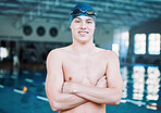 Swimming, sports and  portrait of man by pool for training, competition and exercise in gym. Professional, fitness and male swimmer with crossed arms for challenge, workout and practice for wellness