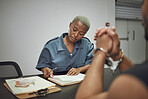 Crime, prisoner and woman police officer at the station writing a legal report for social justice. Law enforcement, security and male thief in handcuffs talking to female guard in interrogation room.