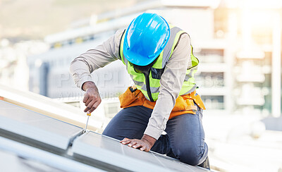 Buy stock photo Man, technician and screwdriver for solar panel installation on rooftop in the city for renewable energy. Male person, engineer or contractor working on roof in sun for installing eco friendly power