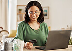 Online shopping, laptop and credit card, woman at table in living room for internet banking app in home with tech. Ecommerce payment, smile and cashback, girl at computer browsing retail website sale