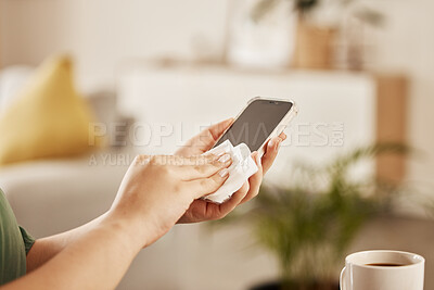 Buy stock photo Closeup of a woman cleaning her phone with paper to prevent germs, dirt or dust bacteria at home. Hygiene, technology and female person wipe her cellphone to sanitize her screen in the living room.