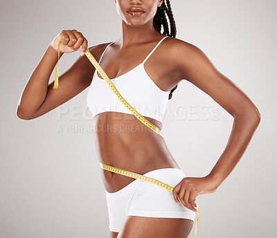Weightloss, health and woman with measuring tape in a studio for her diet,  exercise or wellness. Fi Stock Photo by YuriArcursPeopleimages