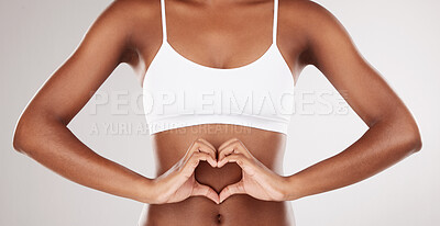 Buy stock photo Body, heart and stomach of a woman for health and wellness on a white studio background. Fitness, gut and diet of aesthetic female model for weight loss, balance or digestion with hands or love emoji