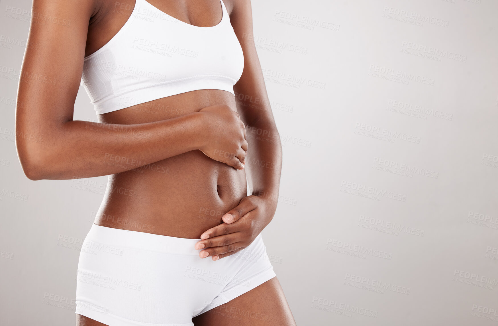 Buy stock photo Hands, body and stomach of a woman for health and wellness on white background in studio. Fitness, gut and diet of person in underwear for weight loss, care or digestion and fertility with space