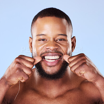 Buy stock photo Portrait, black man and floss teeth in studio, healthy dental care or gum gingivitis. Face of male model cleaning mouth with oral thread for fresh breath, tooth cosmetics or plaque on blue background