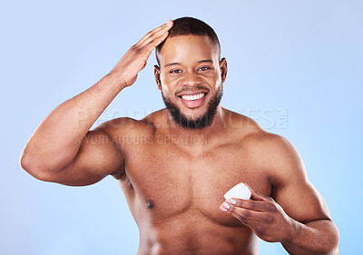 Buy stock photo Beauty, portrait and a black man with cream for hair care, shine and moisture on a blue background. Happy, wellness and an African person or model with gel for growth isolated on a studio backdrop