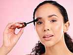Beauty, mascara and makeup on face of a woman in studio for eyelash cosmetics and skin glow. Portrait, application and skincare tools or product of a young female aesthetic model on a pink background