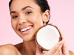 Woman face, coconut fruit and beauty, healthy skincare or vegan cream on pink studio background. Portrait of latino person in natural product for dermatology, eco friendly cosmetics and oil benefits