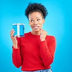 Thinking, winner and black woman with a present, box and celebration against a blue studio background. Female person, ideas or model with a gift, giveaway product or package with surprise and curious