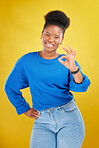 Portrait, black woman and ok sign with a smile, review and feedback against a yellow studio background. Female person, gen z and model with perfect symbol, emoji and happiness with like, icon and yes