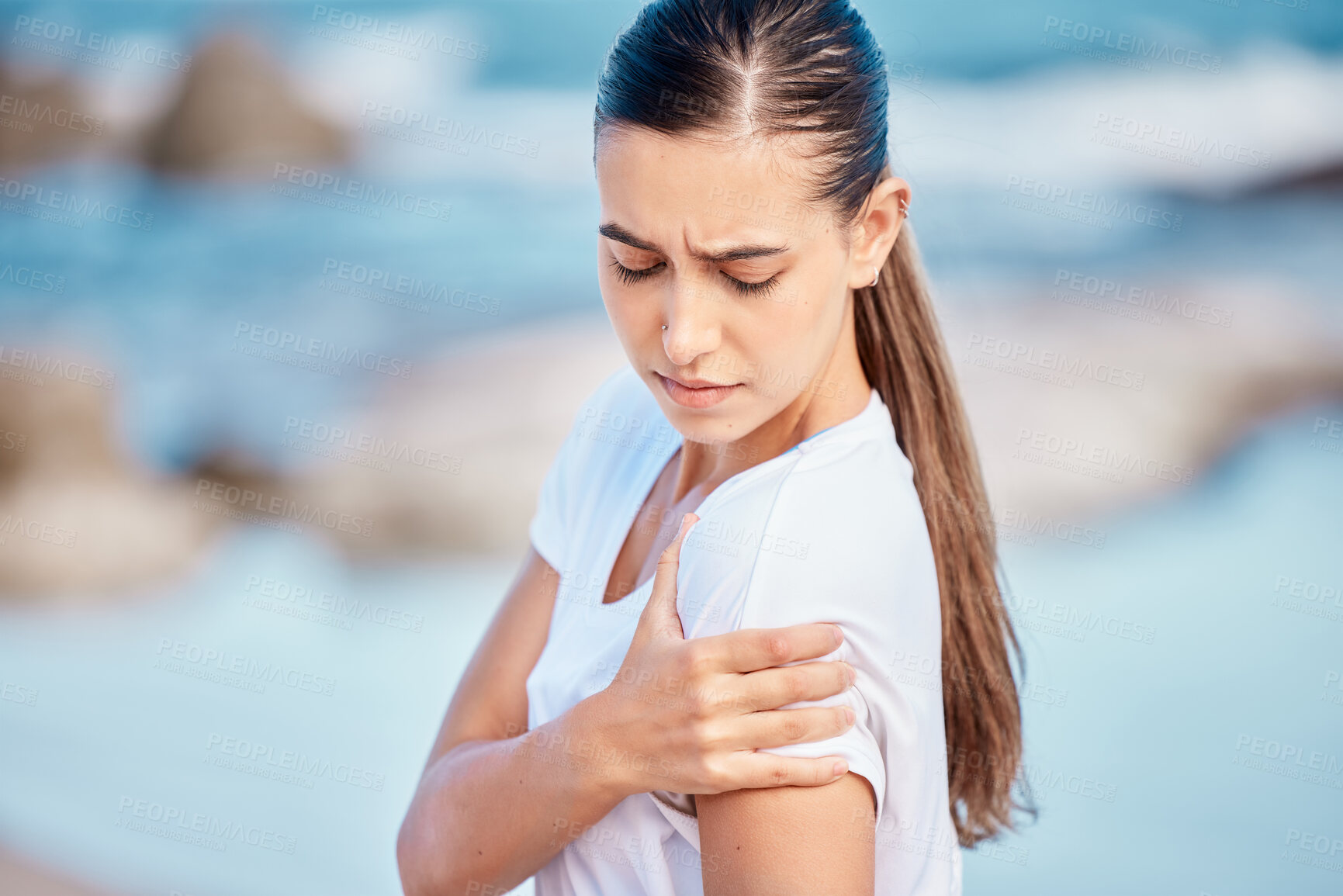 Buy stock photo Woman, fitness and arm pain on beach from workout injury, exercise or outdoor accident. Female person with sore shoulder, joint ache or inflammation and muscle tension after exercise on ocean coast