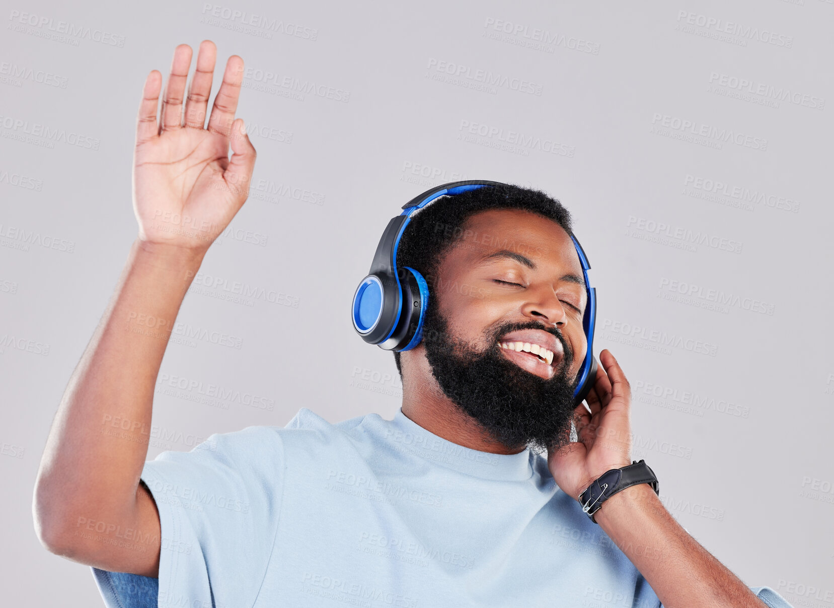 Buy stock photo Headphones, sing and man in a studio with music, playlist or album while dancing with energy. Happy, smile and young African male model listening to a song or radio online isolated by gray background