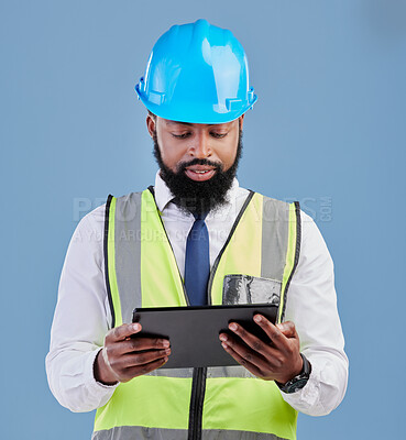 Buy stock photo Black man, architect and tablet for construction inspection or planning against a blue studio background. African male person, engineer or contractor working on technology for industrial architecture