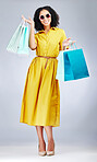 Happy woman, portrait and shopping bags for fashion or style against a white studio background. Excited female person, customer or shopper smile for discount, sale or purchase in promotion with gifts