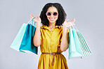 Sunglasses, portrait and happy woman with shopping bag for fashion in studio isolated on a white background. Cool, sales and African customer with gift, discount deal and stylish clothes from store