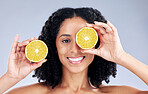 Girl, skincare and lemon eye for wellness in portrait for natural beauty in grey studio background. Happy face, hand and vitamin c with woman for dermatology or facial treatment for diet or care.