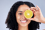 Skincare, smile and lemon eye for nutrition or fruit with glow in grey studio background. Female person, portrait and vitamin c  or natural with facial treatment and organic food for dermatology.