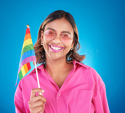 Buy stock photo Woman, lgbtq and rainbow flag in studio portrait, sunglasses and sign for pride with human rights by blue background. Gen z girl, young lesbian student and happy with solidarity, freedom or inclusion