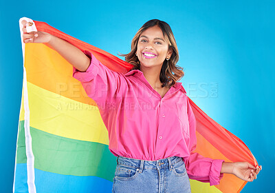 Buy stock photo Lgbtq flag, portrait and woman with support, pride and happiness on a blue studio background. Female person, ally or model with symbol for queer community, equality or transgender rights with freedom