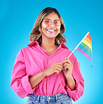 Woman, smile and pride flag in studio portrait with fashion, sunglasses and sign for human rights by blue background. Gen z girl, lesbian student and happy at protest, support and freedom for lgbtq