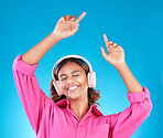 Woman, student headphones and happy music for audio streaming service or mental health podcast in studio. Young person dance or listening to radio for wellness and excited on blue gradient background