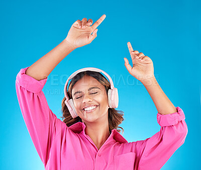 Buy stock photo Woman, student headphones and happy music for audio streaming service or mental health podcast in studio. Young person dance or listening to radio for wellness and excited on a blue background