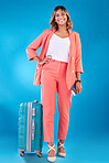Travel, portrait and a woman with luggage on a blue background for a vacation, journey or flight. Smile, ready and a young Indian girl with a suitcase and passport for a holiday on a backdrop