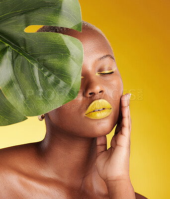 Buy stock photo Beauty, makeup and leaf with face of black woman in studio for tropical, natural and cosmetics. Luxury, sustainability and health with female model on yellow background for plant, salon and wellness