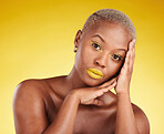 Cosmetics, glow and african girl in portrait for skincare in yellow studio or background for facial. Woman, serious and hand on face with makeup for luxury spa treatment for dermatology or wellness.