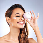 Cream, jar and beauty of happy woman in studio with facial cosmetics product on grey background. Female model, face lotion and skincare container for sunscreen, aesthetic dermatology and moisturizer