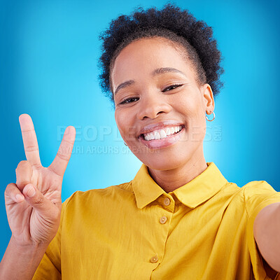 Buy stock photo Happy woman, portrait smile and peace sign for selfie, photography or memory against a blue studio background. African female person or photographer for picture, photo or online social media post