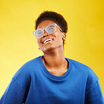 Happy, fashion and glasses with face of black woman in studio for vision, eye care and trendy style. Gen z, smile and happiness with female person on yellow background for expert, health and idea