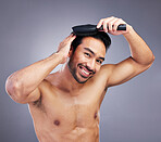 Portrait, beauty or happy man brushing hair in grooming with salon haircare product on studio background. Smile, brush or confident healthy Asian male model with cool hairstyle in morning routine 