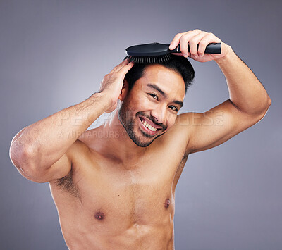 Buy stock photo Portrait, beauty or happy man brushing hair in grooming with salon haircare product on studio background. Smile, brush or confident healthy Asian male model with cool hairstyle in morning routine 