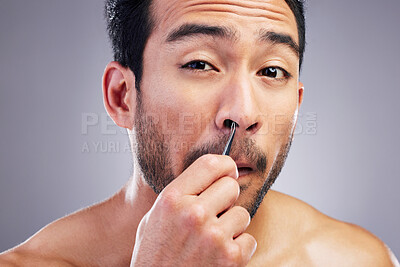 Buy stock photo Tweezer, nose hair and portrait of man in studio for beauty, hygiene or grooming. Pain, epilation and face of an asian male person for skincare, self care and cosmetic tools on grey background