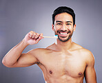 Dental, portrait and a man brushing teeth on a studio background for cleaning, grooming and hygiene. Happy, wellness and an Asian person with a toothbrush for care of mouth isolated on a backdrop