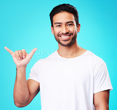 Buy stock photo Man, smile and shaka in studio portrait with sign language, icon and youth by blue background. Indian student guy, fashion model and hand for call me, emoji and happy with gesture, symbol or contact