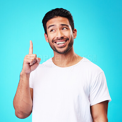 Buy stock photo Mockup, pointing up and man with a smile, thinking and solution against a blue studio background. Male person, decision and model with hand gesture, opportunity or option with sign, choice or showing