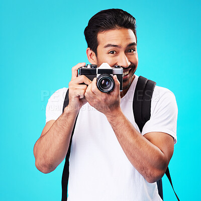 Buy stock photo Portrait, creativity and man with a camera, photography and artist against a blue studio background. Face, male person and model with vintage technology, journalist and photographer with inspiration