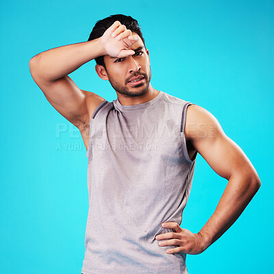 Buy stock photo Portrait, fitness and Asian man tired after exercise in studio isolated on a blue background. Face, serious and athlete with fatigue, wipe sweat and workout for sports, healthy body and wellness