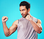 Fitness, man and fighter training, sports and exercise against a blue studio background. Male person, sweating or serious athlete with power, strong or energy with workout goals, fight or competition