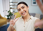 Happy woman, portrait and peace for selfie in home, video call or live streaming vlog in living room. Face of young female gen z show v sign, hand emoji and memory for social media or profile picture