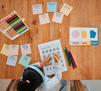 Buy stock photo Above, child and girl writing on table for homework or remote learning in home for development, growth and education. Kid, working and studying for school, math and writing on paper in living room