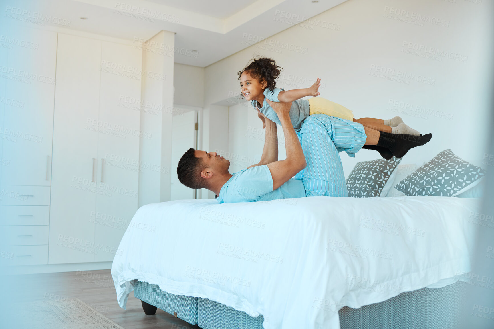 Buy stock photo Airplane, bonding and father playing with his child for quality time, fun or happiness at home. Happy, smile and young dad relaxing with his boy kid in a superhero costume on the bed at family house.