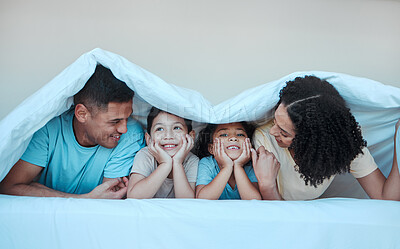 Buy stock photo Blanket, family and parents with children in bed for bonding, quality time and affection in morning. Happy, love and portrait of mother, father and kids in bedroom for fun, playing and relax at home