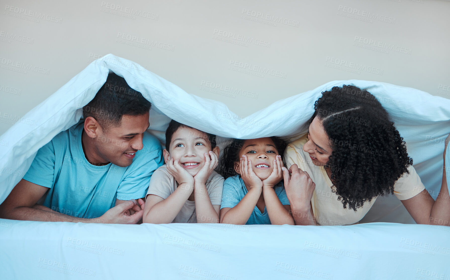 Buy stock photo Blanket, family and parents with children in bed for bonding, quality time and affection in morning. Happy, love and portrait of mother, father and kids in bedroom for fun, playing and relax at home