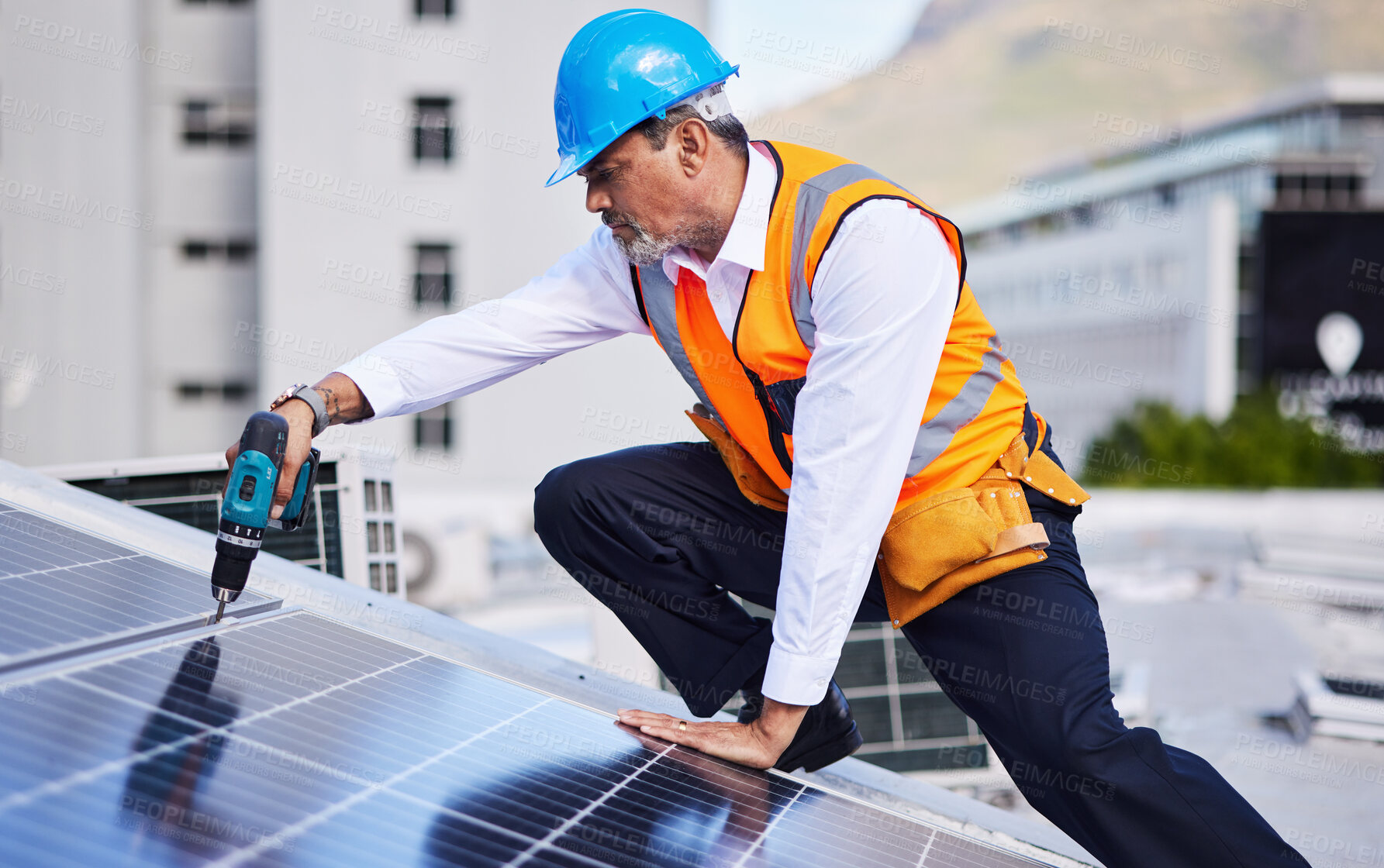 Buy stock photo Solar panels, man and power drill for engineering, grid and building maintenance in city. Electrician, construction tools and inspection of energy saving electricity, photovoltaic system and rooftop